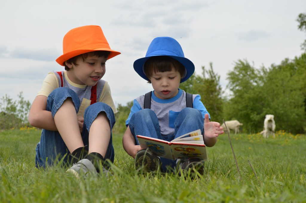 2 small boys reading a book