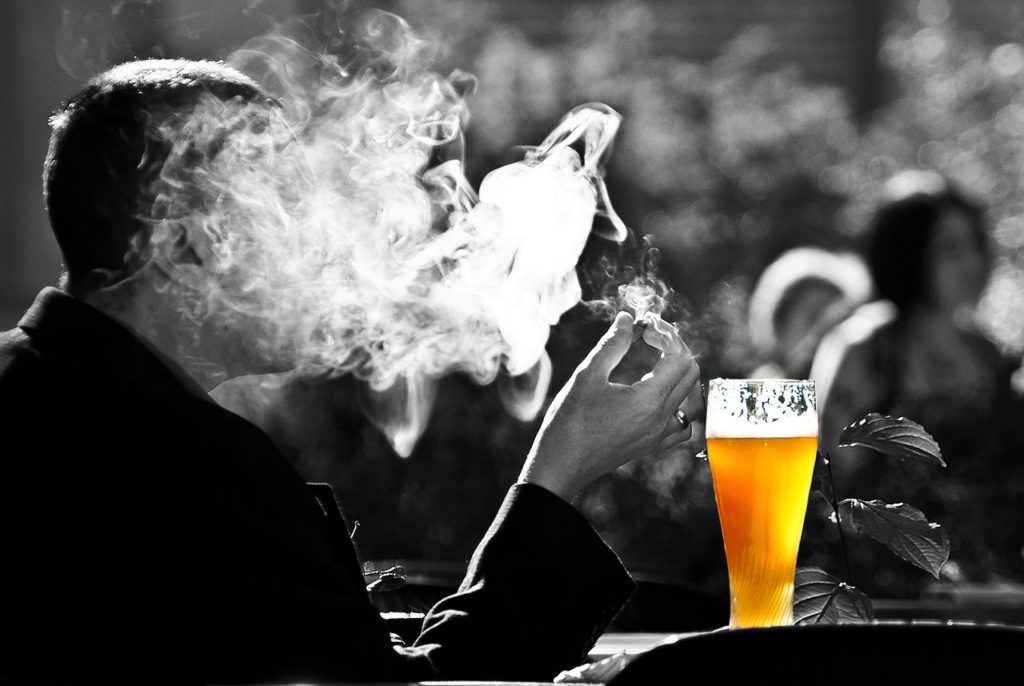 man smoking and drinking